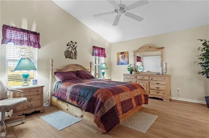 Bedroom with ceiling fan, lofted ceiling, and light hardwood / wood-style flooring