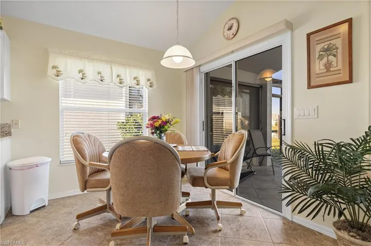 Tiled dining area featuring vaulted ceiling