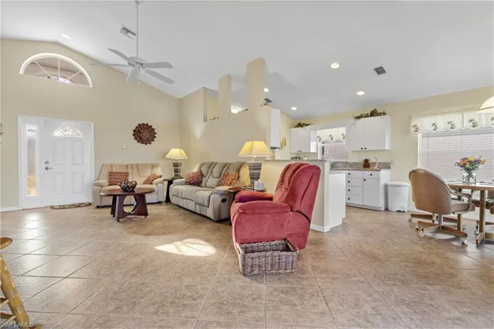 Living room featuring ceiling fan, sink, and high vaulted ceiling