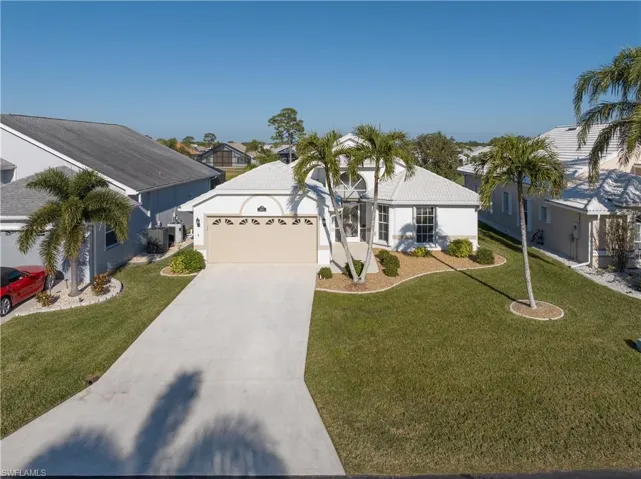 Ranch-style house featuring a front yard and a garage