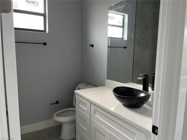 Bathroom with tile floors, oversized vanity, and toilet
