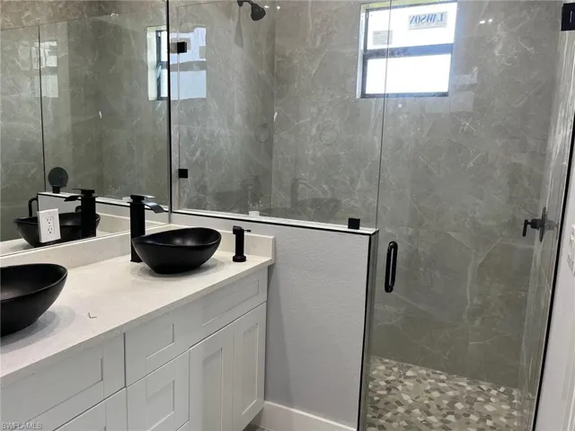 Bathroom featuring dual vanity and walk in shower