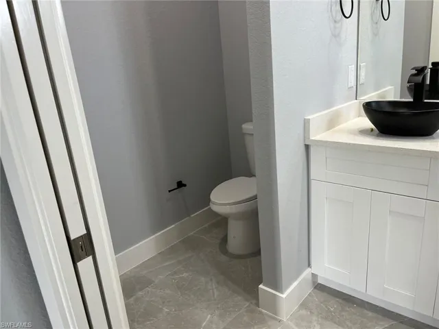 Bathroom with tile flooring, vanity, and toilet