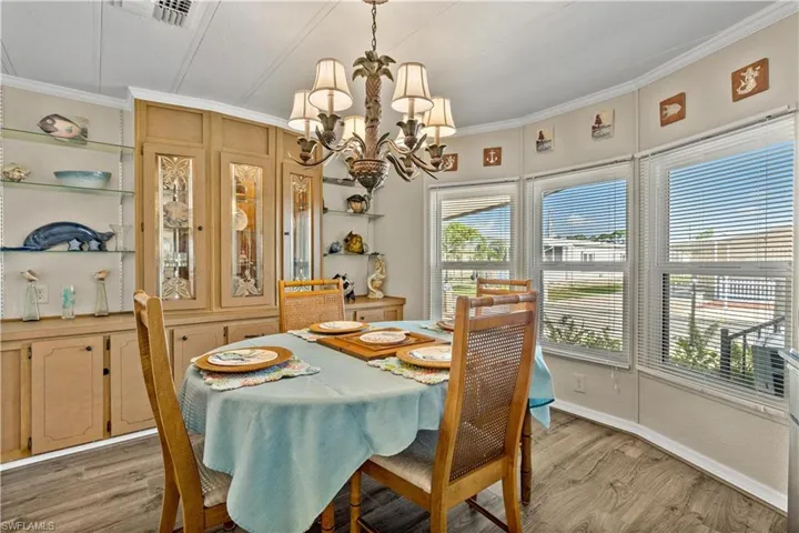 Dining area featuring ornamental molding, hardwood / wood-style flooring, and a chandelier