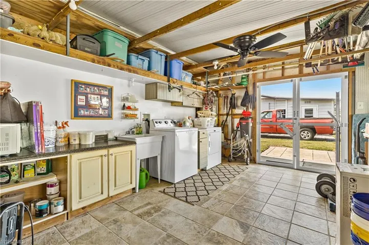 Washroom with ceiling fan, washer and dryer, cabinets, and light tile floors