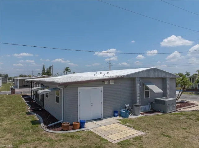 Rear view of property with a yard and central AC unit