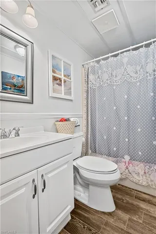 Bathroom featuring wood-type flooring, vanity, and toilet