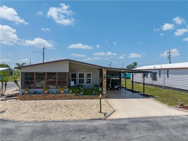 Manufactured / mobile home with a front yard and a carport