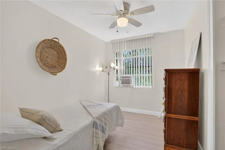 Bedroom 3 with light wood-style floors, a ceiling fan, and cooling unit