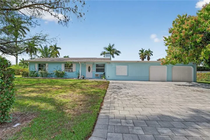 Single story home with a front lawn, decorative driveway, a porch, and a garage