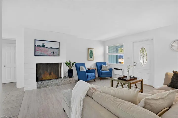 Living area with a fireplace and light wood-style plank flooring