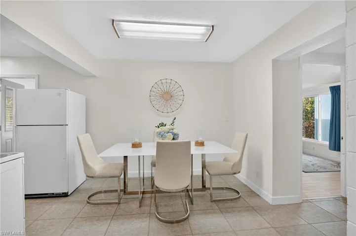 Dining room with light tile patterned flooring and baseboards