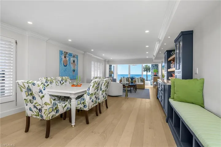 Dining area with light wood-style flooring, crown molding, and recessed lighting