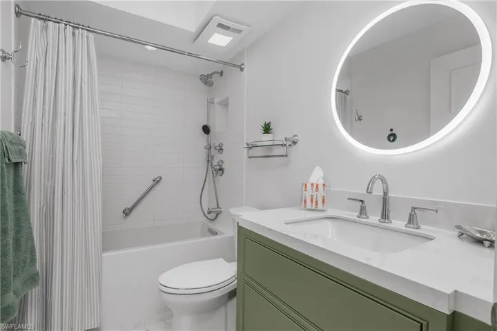 Custom tile and cabinetry in Full bath with vanity, shower/bathtub combination, and  lighted vanity mirror