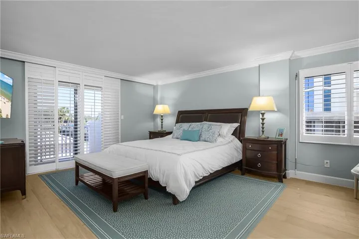 Main Bedroom with access to exterior balcony, light wood floors, and crown molding