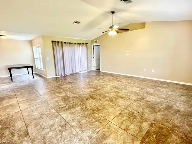 Unfurnished room with vaulted ceiling and ceiling fan