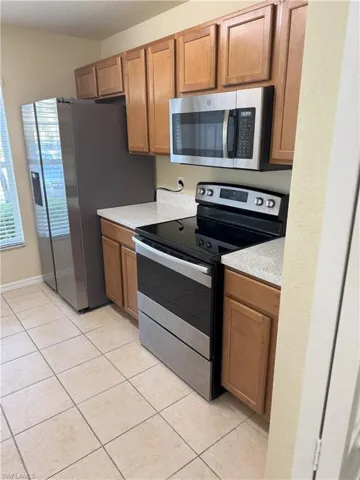 Kitchen featuring light tile patterned floors and stainless steel appliances