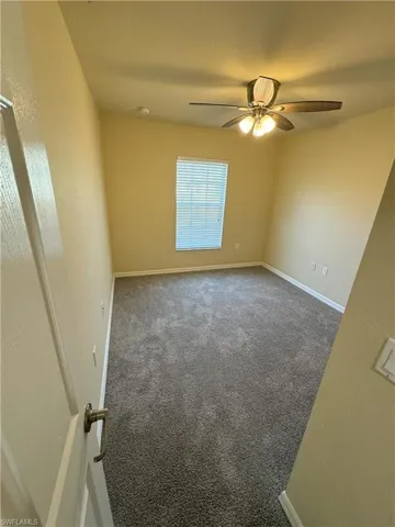 Spare room featuring carpet floors and ceiling fan