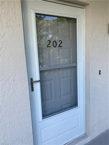 Doorway to property with stucco siding