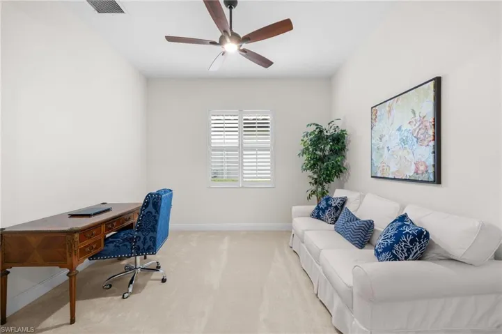 Carpeted office featuring ceiling fan