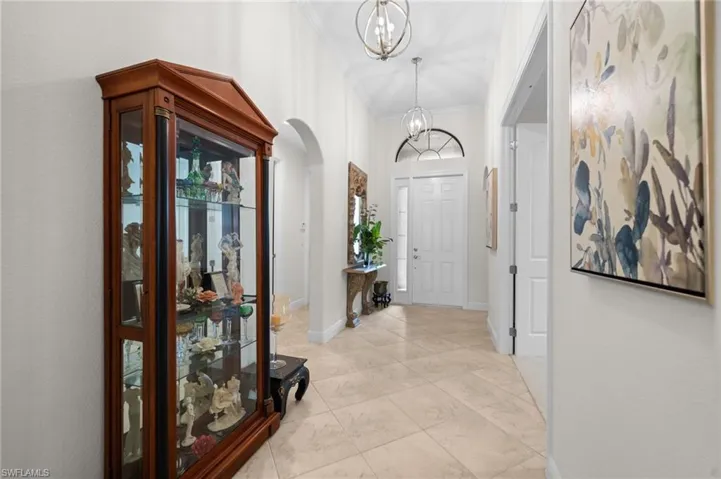 Entryway with an inviting chandelier and crown molding