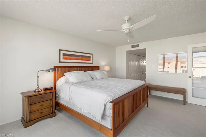 Bedroom featuring a closet, a textured ceiling, ceiling fan, and carpet