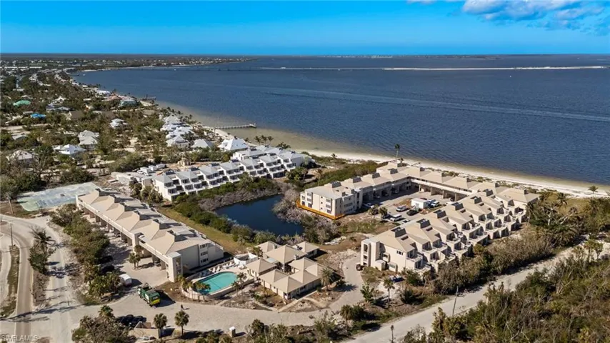 Aerial overview of property's location featuring apartment complex and a large body of water