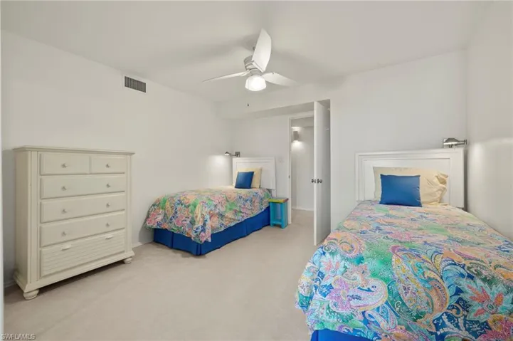 Carpeted bedroom with a ceiling fan