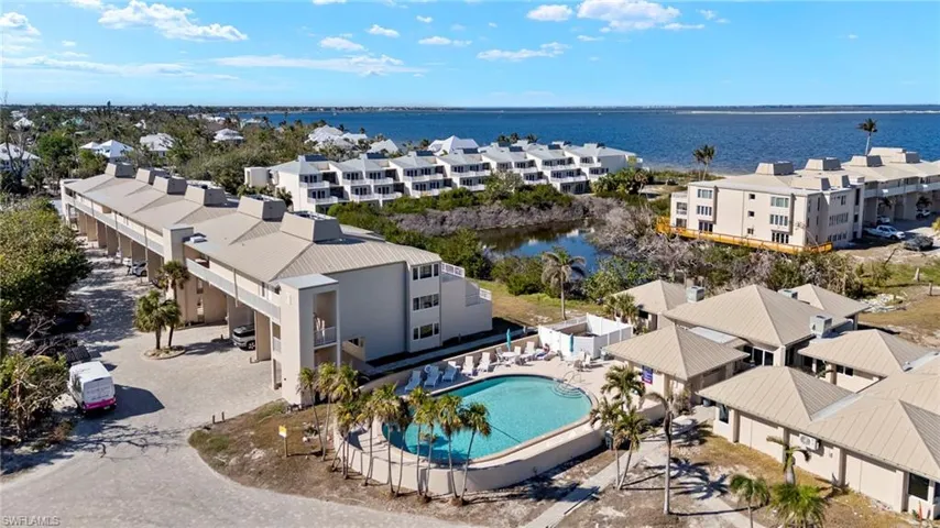 Aerial view of a pool area and a large body of water