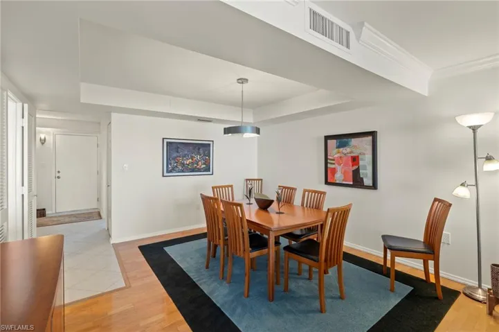 Dining room featuring light wood finished floors and a tray ceiling