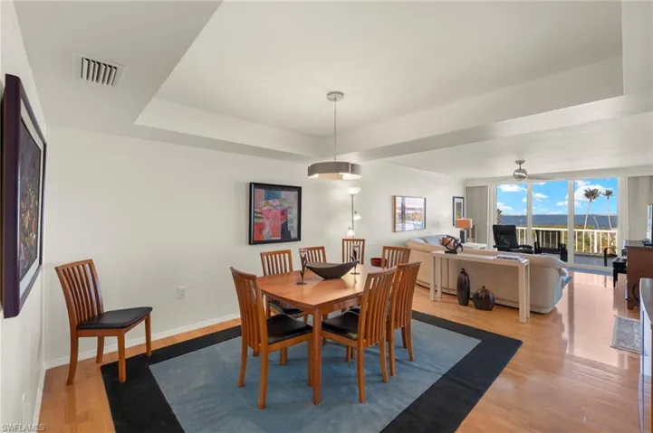 Dining space featuring light wood-style floors and a tray ceiling