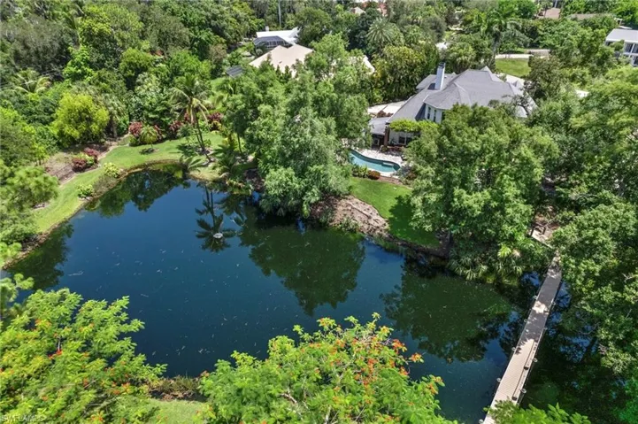 Bird's eye view of a tree filled landscape and a large body of water
