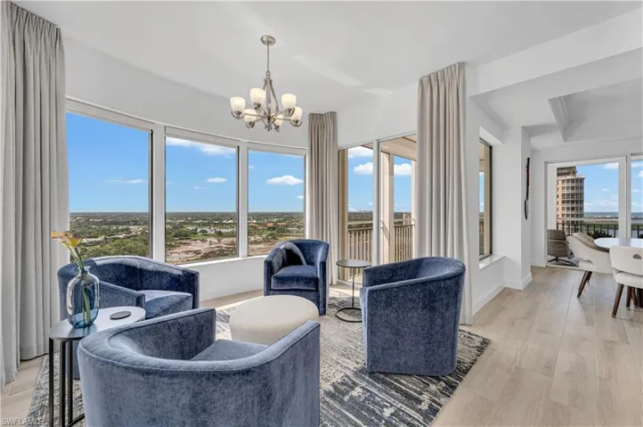 Sitting room off kitchen wealth of natural light, a chandelier, and light hardwood / wood-style flooring