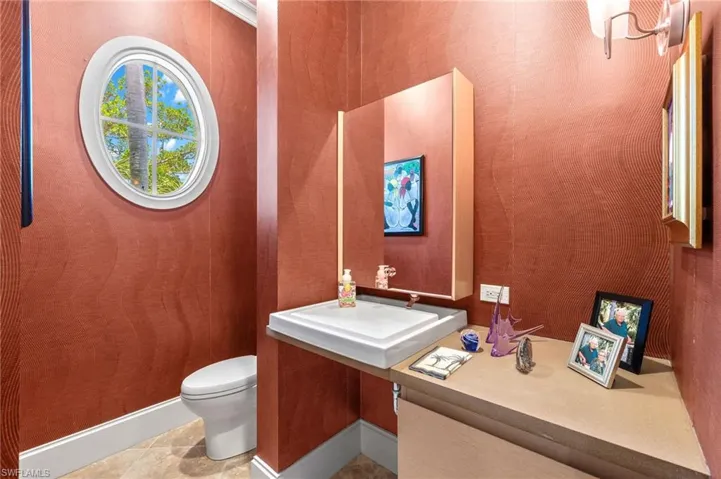 Bathroom with toilet, sink, and tile patterned flooring