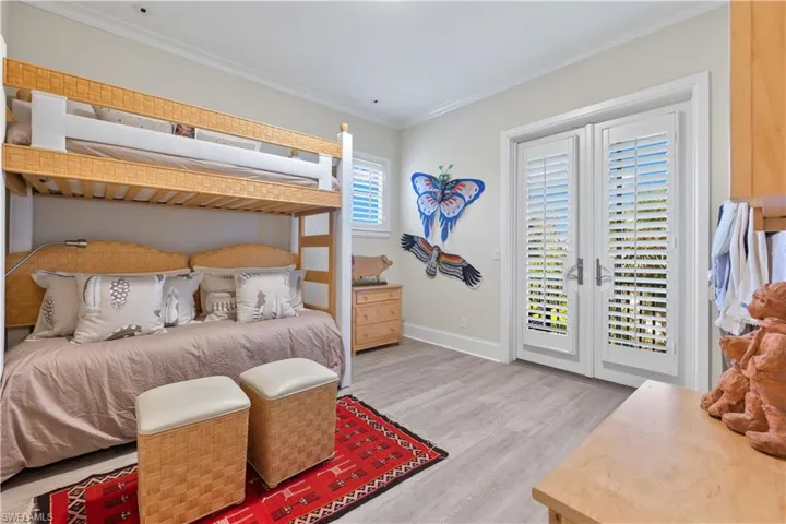 Bedroom with light hardwood / wood-style floors, access to outside, and ornamental molding