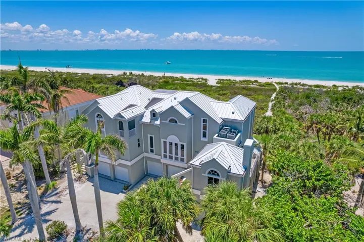 Birds eye view of property featuring a water view and a view of the beach