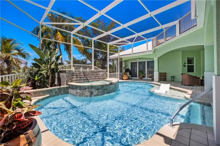 View of pool with an in ground hot tub, a patio, a lanai, and ceiling fan