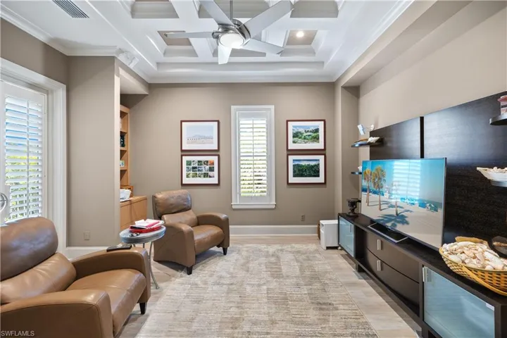 Living area featuring beam ceiling, ceiling fan, light hardwood / wood-style flooring, ornamental molding, and coffered ceiling