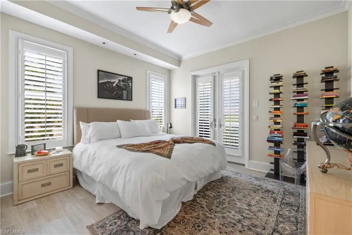 Bedroom featuring light wood-type flooring, multiple windows, access to outside, and ceiling fan