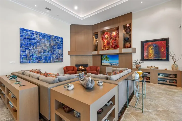 Tiled living room with crown molding and a fireplace