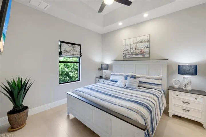 Bedroom featuring ceiling fan, recessed lighting, and a tray ceiling