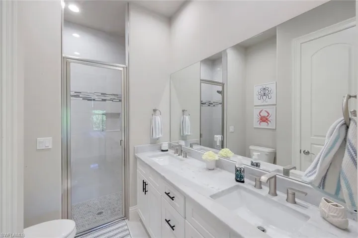 Bathroom featuring double vanity, a stall shower, and recessed lighting