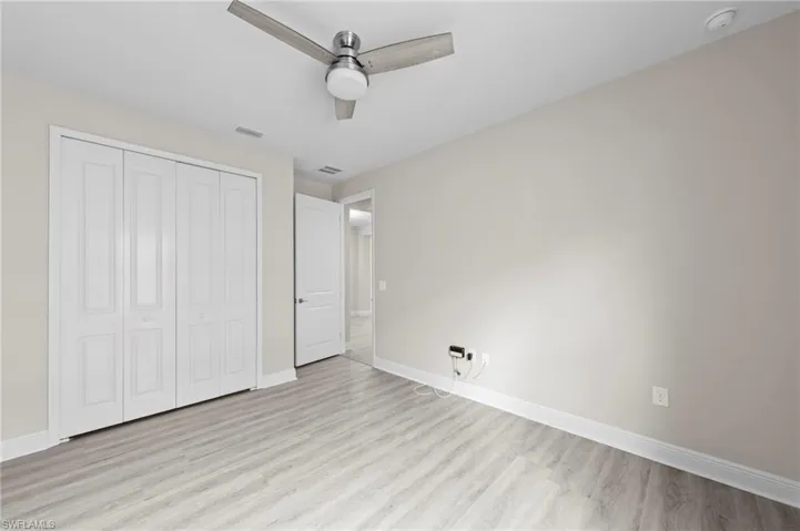 Room featuring wood-finish flooring, light neutral wall paint, and white trim
