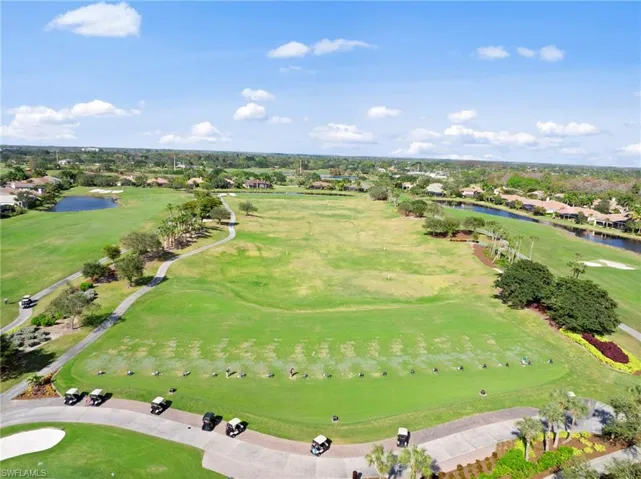 Expansive golf course and surrounding community with abundant green space and water features