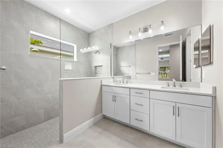 Contemporary bathroom featuring a spacious walk-in shower with full tile surround, a built-in shower niche, and a horizontal window
