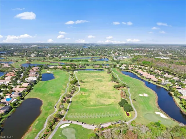 Expansive golf course setting featuring manicured greens and multiple water features