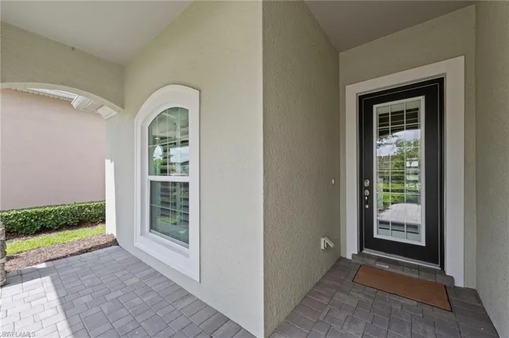 Covered entry with pavers and a transom window main door