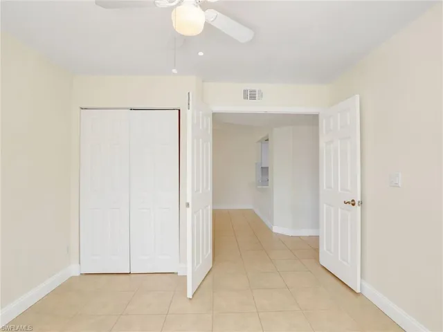 Unfurnished bedroom featuring a closet, ceiling fan, and light tile patterned flooring