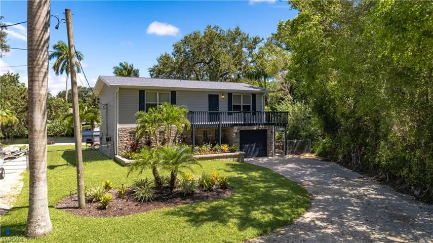 View of front facade featuring a garage and a front lawn