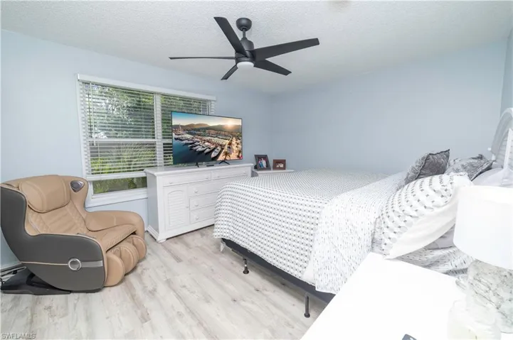 Bedroom featuring a textured ceiling, light hardwood / wood-style flooring, and ceiling fan
